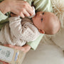 Baby being held in arms, with face being wiped with Dr. Talbot's Baby Wipes.