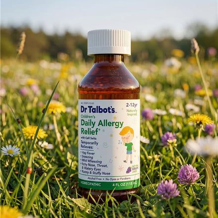 A bottle of Dr. Talbot’s Daily Allergy Relief homeopathic liquid for children sitting in a field of wildflowers.