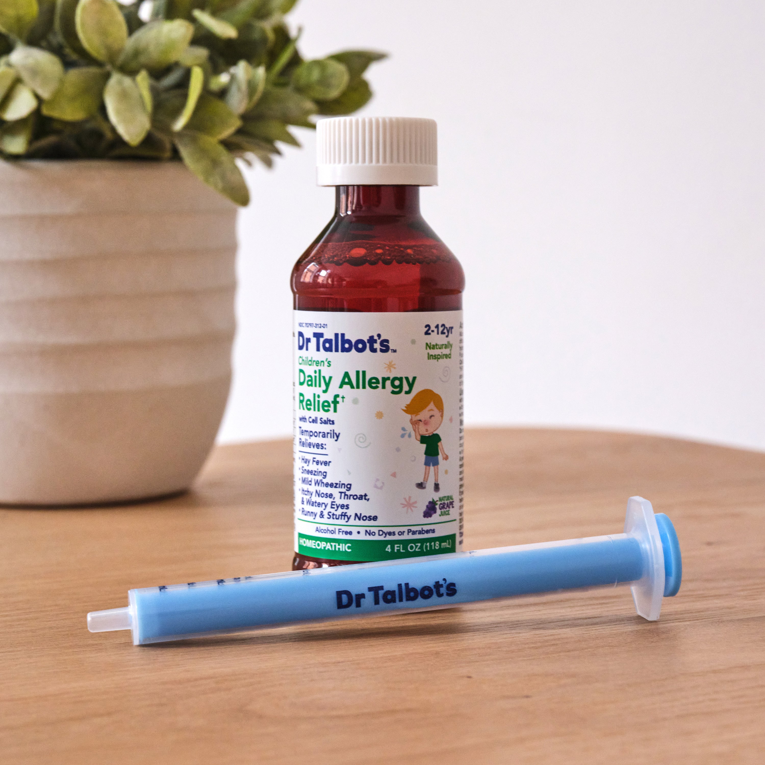 A bottle of Dr. Talbot’s Daily Allergy Relief liquid and a blue oral medicine syringe.