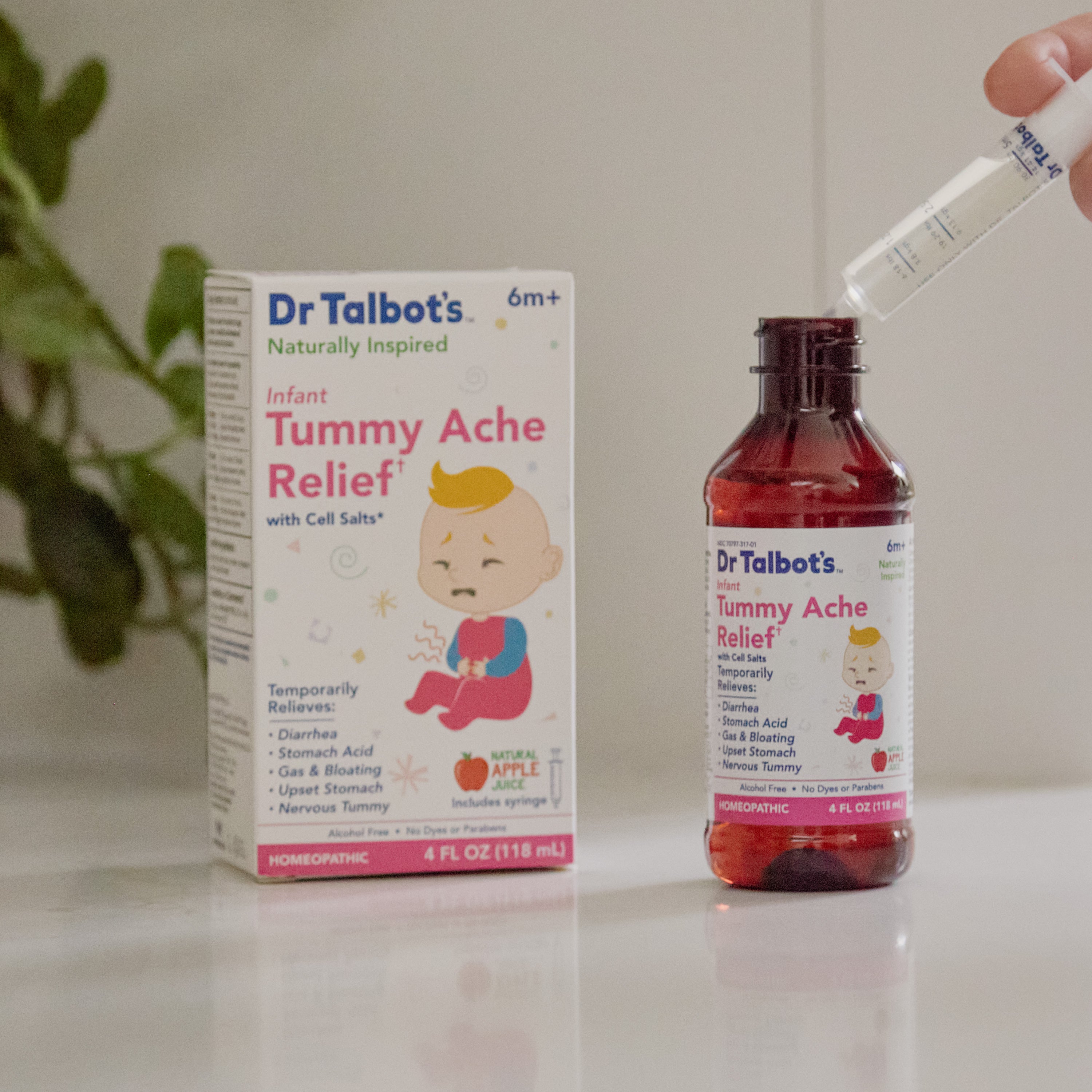 A bottle of Dr. Talbot’s Infant Tummy Ache Relief and a dropper being filled, positioned next to the product box.