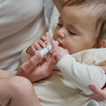 An adult holds a liquid Dr. Talbot’s Infant Mucus + Cold Relief syringe to an infant’s mouth for cold relief.