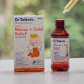 Dr. Talbot’s Infant Mucus + Cold Relief bottle and box, with a dropper filled with liquid held above the open bottle.