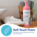 A bottle of Dr. Talbot's Mom Soft Touch Foam from the Postpartum Recovery Kit sits on a towel with foam beside it. Text reads: “Soft Touch Foam. Soft, gentle foam dispenses easily from the nozzle.”.