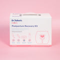 A white Dr. Talbot's Mom Postpartum Recovery Kit box sits on a pink background, displaying illustrations and text highlighting included essentials like a peri bottle, pads, liners, and foam for perineal care.